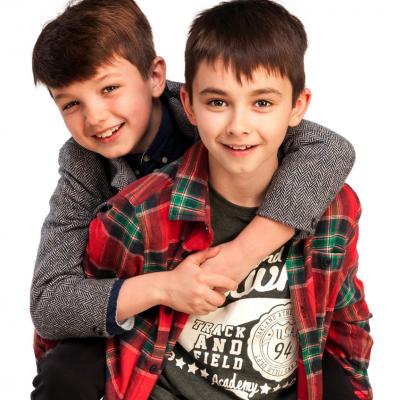 A kids giving his brother a piggy back ride.